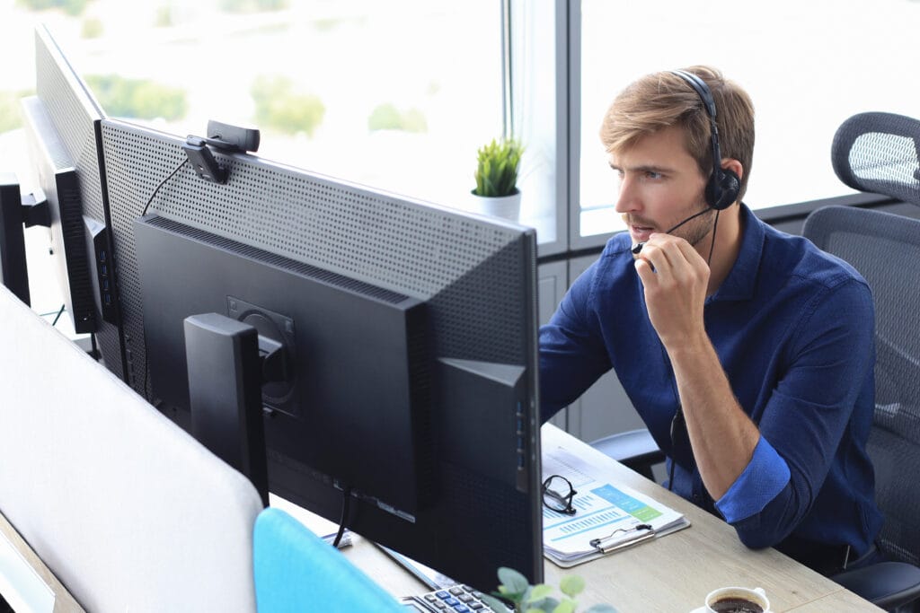 Happy young male customer support executive working in office.