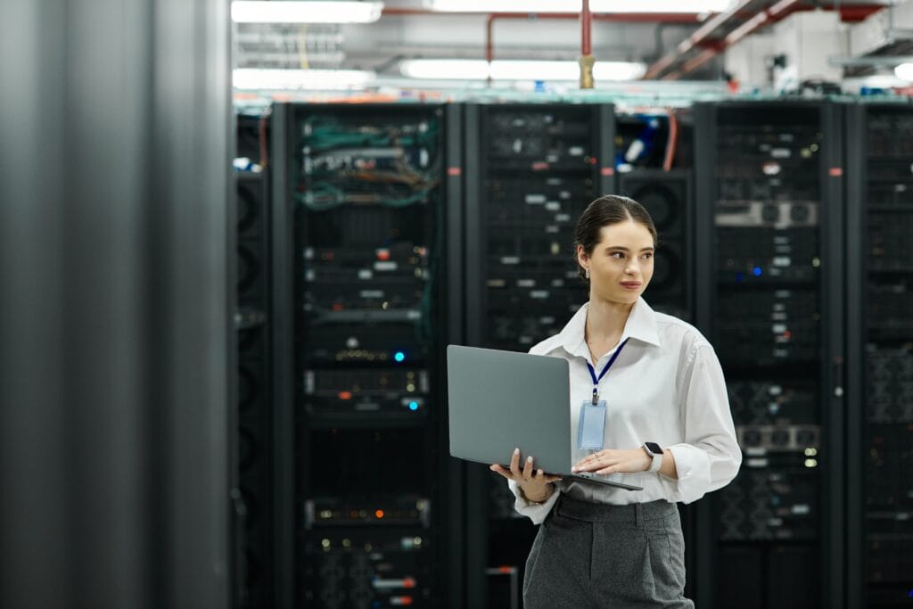A skilled IT specialist works diligently in a high-tech server room, handling complex systems.
